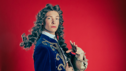 Johannes Wirix-Speetjens ist für Classical Queers mit blauem Plüsch-Blazer und grauer Lockenperücke als König Louise XIV. kostümiert.