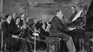 Der Komponist Camille Saint-Saëns am Klavier