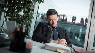  Ein Mann schlaeft in einem Buero  an seinem Schreibtisch (gestellte Szene).