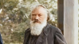 Digital bearbeitetes Foto von 1894: Der Komponist Johannes Brahms vorgrünen Bäumen.