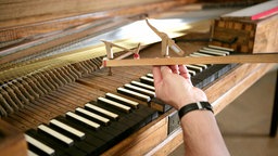 Klavierbaumeister Becker aus Baden-Baden misst ein Hammerklavier aus, auf dem W. A. Mozart gespielt haben soll.