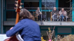 Symbolbild: Der Musiker Karsten Lauke am Kontrabass spielt ein kleines Konzert vor einem Seniorenheim.
