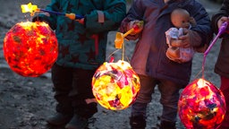 Kinder laufen mit ihren Laternen beim Sankt-Martins-Umzug mit.
