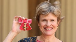 Die britische Komponistin Rachel Portman hält ihre Auszeichnung des britischen Ritterordens in die Höhe.