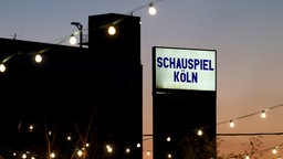 Der abendliche Blick auf ein Schild des Schauspiel Köln am Schauspiel Köln im Depot.