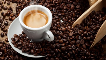 Tasse mit Espresso und Kaffeebohnen