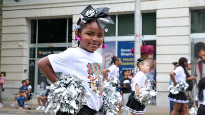 Ein Mädchen der Harrisburg Cougars Cheerleaders läuft 2025 bei der Juneteenth Parade in Harrisburg, USA mit.