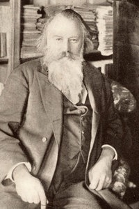 Der Komponist Johannes Brahms sitzt in seiner Bibliothek