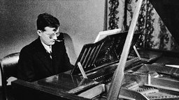 Schwarz-Weiß-Aufnahme: Der russische Komponist Dmitri Schostakowitsch (1906-1975) am Klavier.