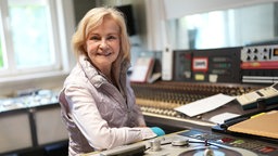 Heikedine Körting im Tonstudio vor einem analogen Tonbandgerät.