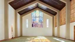 Symbolbild: Ein großer leerer ehemaliger Kirchenraum, mittlerweile mit japanischer Anmutung, durch dessen bunte Glasfenster hellen Licht einfällt.