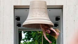 Eine Performerin läutet eine Glocke mit ihrem Körper im österreichischen Pavillon "Seaworld Venice" auf der 61. Kunstbiennale Venedig 2026. 