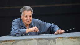 Schwarz-Weiß-Bild von 2021: Der Dirigent Peter Gülke lehnt sich während der Medienprobe "Fidelio oder die eheliche Liebe" an der Kammeroper Schloß Rheinsberg aus seinem Orchestergraben. 
