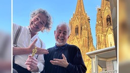 Doppelportrait: Daniel Finkernagel und Helmut Zerlett vor dem Kölner Dom.