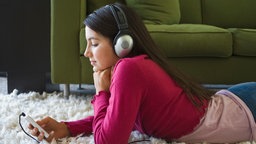 Eine junge Frau hört Musik.