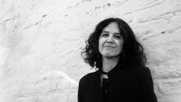 Die mexikanische Komponistin Hilda Paredes lehnt an einer Hauswand