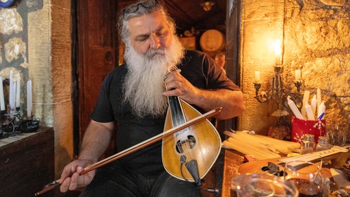 Ein Mann spielt auf der Lyra, einem griechischen Streichinstrument.
