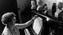 Schwarz-Weiß-Foto: Die Hellseherin Rosemary Brown sitzt am Klavier, durch das sie nach eigenen Angaben neue Kompositionen von Liszt, Beethoven, Schubert, Bach und Chopin empfängt.