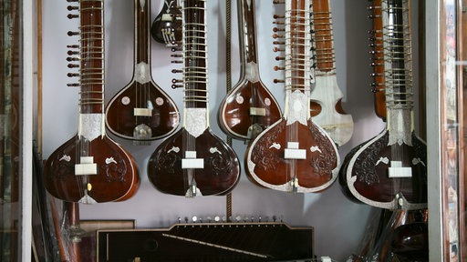 Sitars hängen in einem Schaufenster.