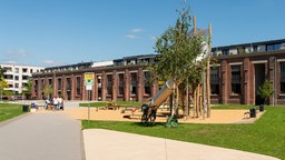Luftschiff-Platz mit Wegen und belebtem Spielplatz und Wohngebäude im Clouth-Quartier Köln.