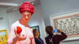 Besucher betrachten Kunstwerke auf der Art Cologne.