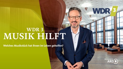 Eckart von Hirschhausen im Foyer des WDR 3 Funkhauses, daneben der Schriftzug: "WDR 3 Musik hilft".