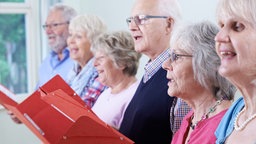 Smybolbild: Senioren und Seniorinnen singen gemeinsam in einem Chor.