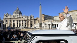 Papst Leo XIV. nimmt am 12. November 2025 an der wöchentlichen Generalaudienz auf dem Petersplatz im Vatikan teil. Er winkt den Menschen vom Papstmobil zu. Im Hintergrund ist der Petersdom.