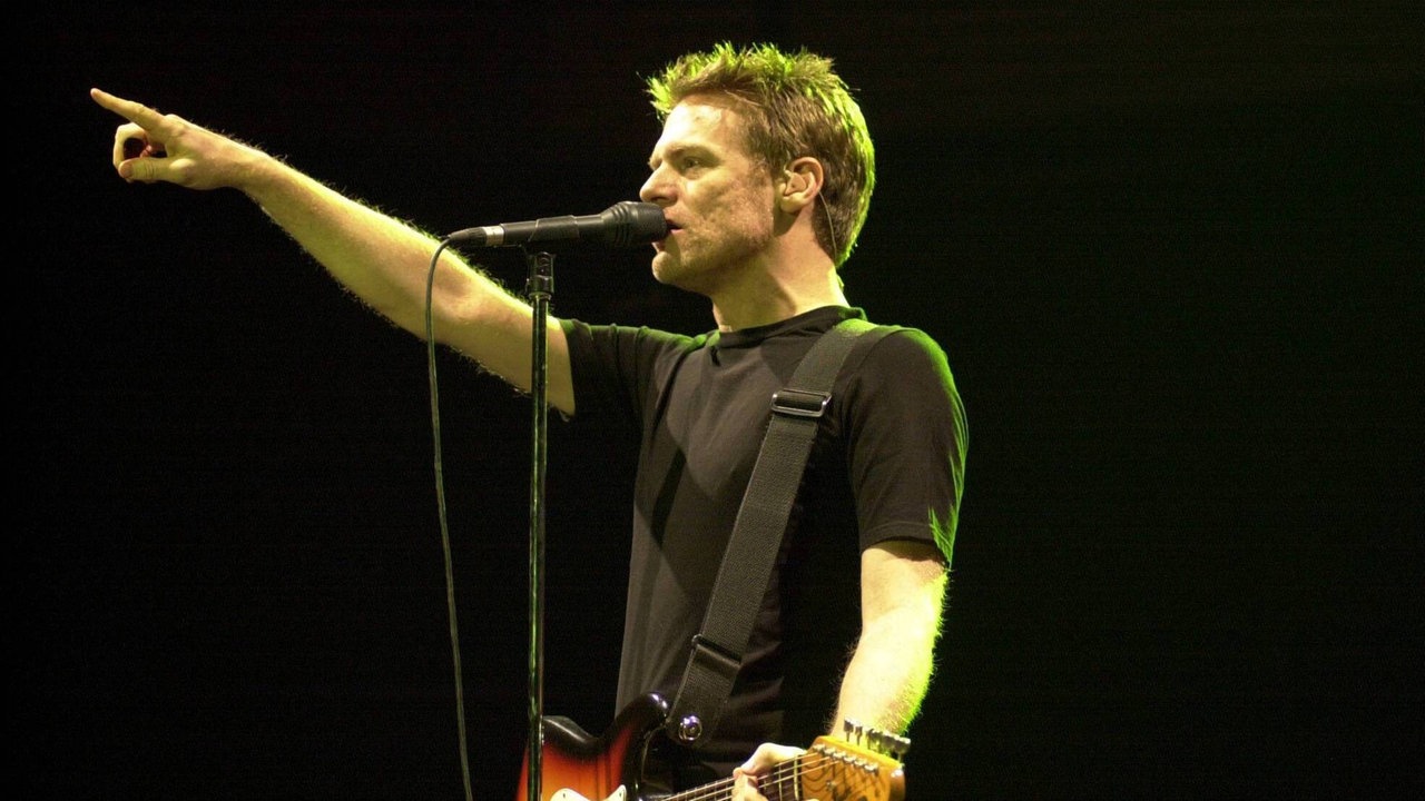 Bryan Adams singt und spielt Gitarre auf der Bühne