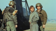 Szene aus "Das Arche Noah Prinzip": Schauspieler Richy Müller neben Piloten und Hubschrauber am Boden, 1983