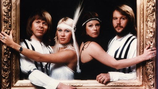 Die Mitglieder der Band ABBA posieren in einem goldenen Bilderrahmen (Aufnahme aus den 70er Jahren)