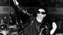 Bono von U2 reckt bei einem Auftritt in Frankfurt in den 90ern sein Mikrofon in die Höhe