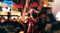 Nicole Sims, gespielt von Donna Summer, steht im Film "Thank God It's Friday" (1978) bei einem Auftritt in einer Disco/Bar im Publikum und singt