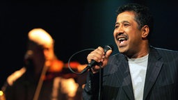 Der algerische Sänger Cheb Khaled 2004 bei einem Auftritt in Genf