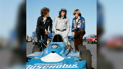 Der Rennfahrer und Prinz von Bayern Leopold hält sich zusammen mit Udo Lindenberg und einem Freund am Rande einer Rennstrecke auf, ca. 1980er Jahre