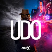 Udo Lindenberg von hinten vor Leuchtreklame und sw-Himmel mit Wolken