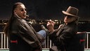 Udo Lindenberg und Apache 207 sitzen nebeneinander und posieren in schwarzen Outfits mit Sonnenbrille und Zigarre