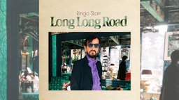 Das Cover des Albums "Long Long Road" zeigt Ringo Starr in lässigem Look mit Sonnenbrille, lila Rüschen-Hemd und Sakko in einem loft-artigen Raum