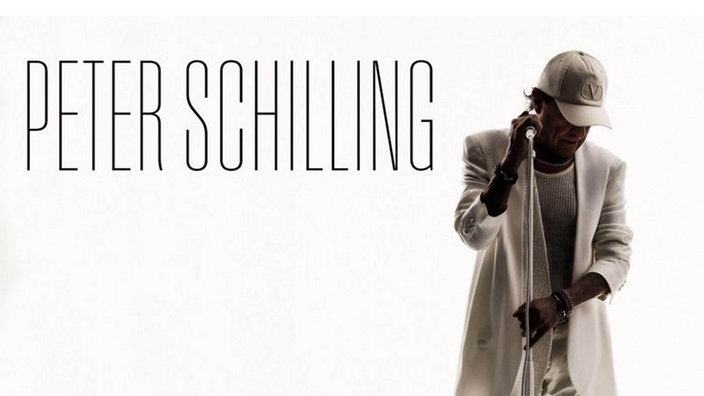Peter Schilling mit einem Mikrofonständer. er schaut zum Boden. Daneben steht sein Name.