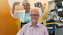 Ralf Kramp und Heike Knispel im WDR 4 Studio. Ralf Kramp sitzt am Mikrofon, Heike Knispel steht hinter ihm und zeigt mit beiden Händen auf ihn. 