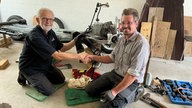 Georg aus Bad Salzuflen mit Christian, der ihm geholfen hat, reine rote 2CV-Ente wieder fit zu machen