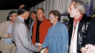Prinz Charles gibt Roger Daltrey bei einem Treffen mit der Band die Hand.
