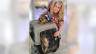 Anke Reichenauer am Flughafen mit einem Hund im Transport-Käfig