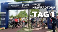 Radfahrer beim Start im Startbogen der NRWRadtour 2025