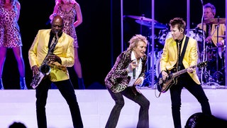 Rod Stewart tanzt auf der Bühne neben seinem Gitarristen