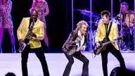 Rod Stewart tanzt auf der Bühne neben seinem Gitarristen