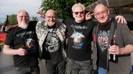 Vier männliche Fans mit Band-T-Shirts