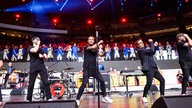Lachende Köln Arena 2026: Die Mitglieder der Band Räuber stehen auf der Bühne in einer Reihe und tanzen zu ihrem Lied "Oben. Unten." 