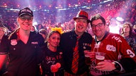 Lachende Köln Arena 2026: Vier verkleidete Fans schunkeln