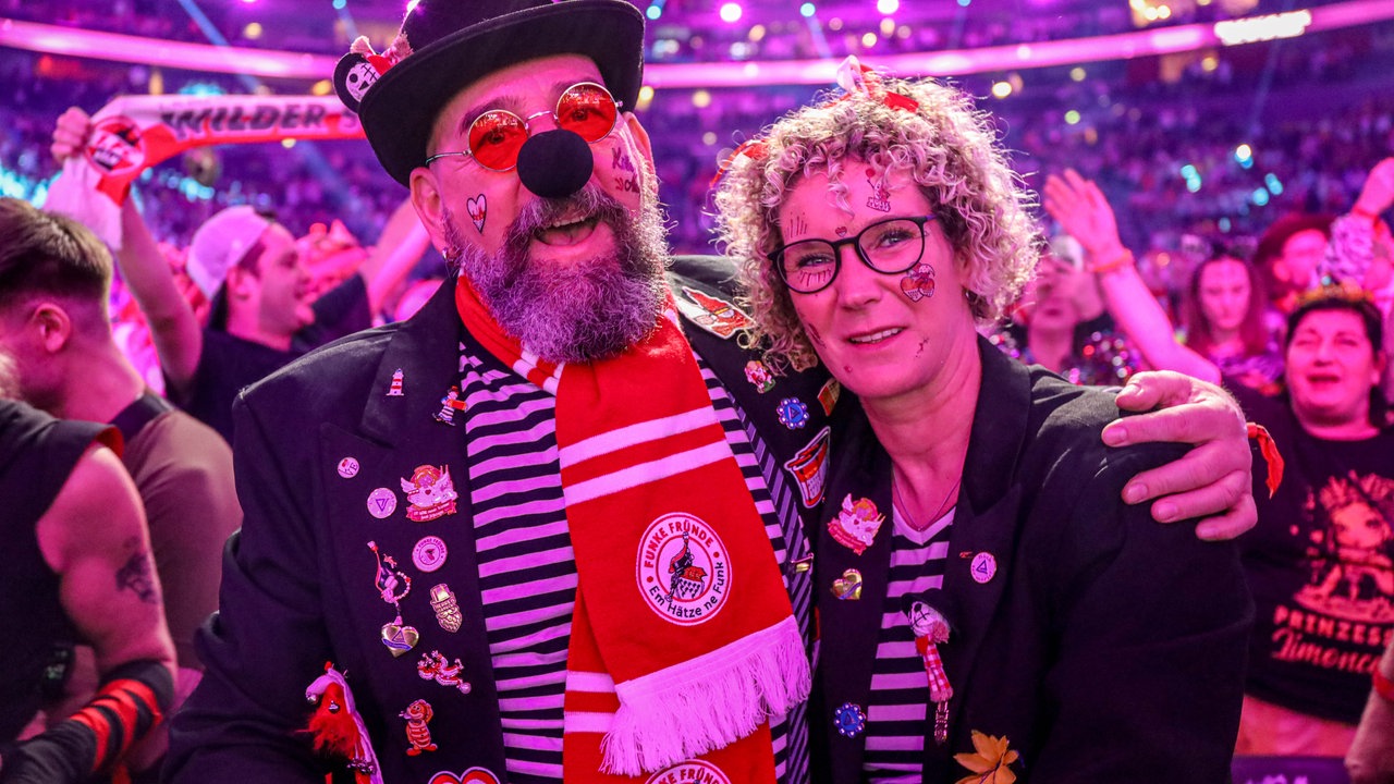 Lachende Köln Arena 2026: Ein verkleidetes Pärchen singt 
